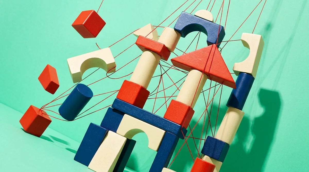 Red, blue and natural wooden building blocks tied together with red threads, like the page structure of a website